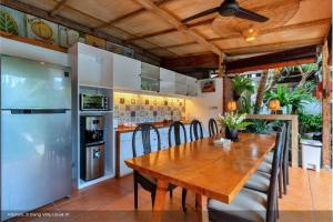 uma cozinha com uma mesa de madeira e um frigorífico em Jixiang Hotel Ubud em Ubud
