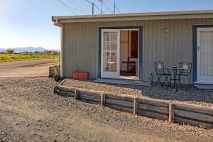 ein kleines Haus mit einem Tisch und Stühlen davor in der Unterkunft Orchard Flat - Mapua Holiday Unit in Upper Moutere