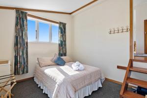 Upper MoutereにあるOrchard Flat - Mapua Holiday Unitのベッドルーム(ベッド1台、窓付)