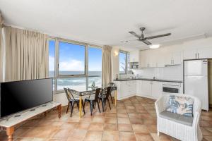 eine Küche und ein Esszimmer mit einem Tisch und Stühlen in der Unterkunft Impressive Waterfront at Chateau Beachside Resort in Gold Coast