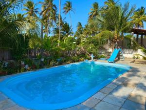 a large blue swimming pool with a slide and palm trees at Pousada Recanto dos Parente - Icaraizinho de Amontada in Amontada