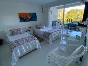 1 dormitorio con 2 camas y balcón en Apartamentos Classy Reef alado de la playa en San Andrés