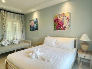 a bedroom with a bed with two towels on it at สายลม รีสอร์ท เขาใหญ่ in Pak Chong +15 photos