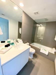 a bathroom with a sink and a toilet and a mirror at Monte Carlo Suites in Miami Beach in Miami Beach