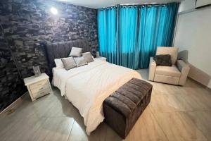 ein Schlafzimmer mit einem großen Bett und einem Stuhl in der Unterkunft Linda casa en playa de Pozos Colorados in Santa Marta