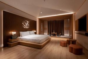 a bedroom with a large bed and a large window at Hyakumangoku Onsen Hotel in Shanghai