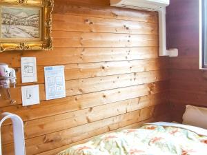 a bedroom with a wooden wall with a bed in it at Minamitsuru-gun - Hotel / Vacation STAY 45535 in Yamanakako