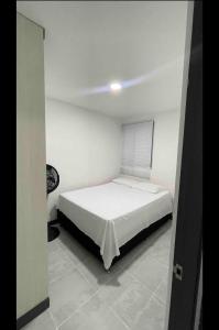 a bedroom with a bed in a white room at ¡Vista Increíble Apartamento Tamarindo! in Santa Fe de Antioquia