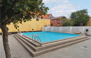 a swimming pool in a yard next to a fence at Stunning Apartment In Gudhjem With Wifi in Gudhjem