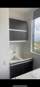 a white kitchen with a sink and a window at ¡Vista Increíble Apartamento Tamarindo! in Santa Fe de Antioquia