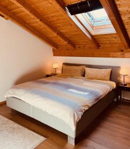 a bedroom with a large bed with a skylight at Haus Oberland in Bad Endorf