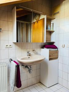 a bathroom with a sink and a cabinet and towels at Haus Oberland in Bad Endorf