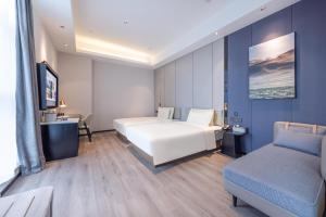 a hotel room with a bed and a couch at Atour X Hotel Shanghai Shuguang Wusong Cruise Terminal in Hujiazhai