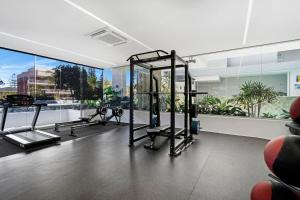 a gym with several tread machines and a large window at Wave Watcher's Delight at Acqua Palm Beach in Gold Coast