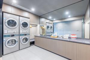 una lavandería con 4 lavadoras y una barra en Atour X Hotel Shanghai Shuguang Wusong Cruise Terminal, 