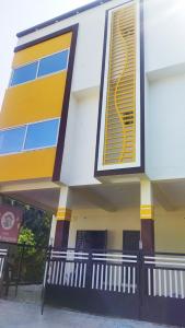 un edificio blanco y amarillo con una valla en Arangan kudil, en Srīrangam