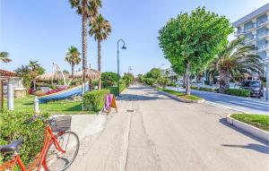 a bike parked on the side of a street with palm trees at Nice Home In Bellante With Kitchen in Bellante