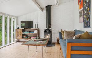 sala de estar con sofá y estufa de leña en Pet Friendly Home In Faxe Ladeplads With Wifi, en Fakse Ladeplads