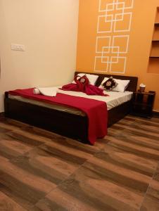 a bedroom with a bed with two stuffed animals on it at Arangan kudil in Srīrangam