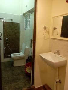a bathroom with a sink and a toilet and a shower at Arangan kudil in Srīrangam