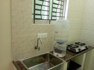a kitchen sink with a blender on top of it at Arangan kudil in Srīrangam