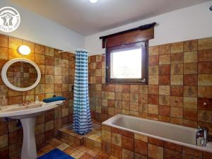 a bathroom with a tub and a sink and a window at Villa d'architecte 200m² avec piscine privée et cheminée - FR-1-496-35 in Pommiers-en-Forez +19 photos