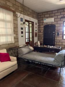 a living room with two beds and a couch at IRUPE/Casa completa /pileta/cercana al rio in Paganini +1 photo