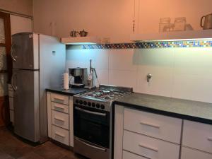 a kitchen with a stove and a refrigerator at IRUPE/Casa completa /pileta/cercana al rio in Paganini