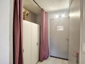 uma casa de banho com um armário com uma cortina rosa em Studio Lamalou-les-Bains, 1 pièce, 2 personnes - FR-1-451-197 em Lamalou-les-Bains