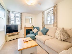 a living room with a couch and a tv at Tidnor Cross Mews in Hampton Bishop