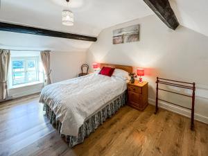 um quarto com uma cama e piso em madeira em Fedwr Gog Cottage em Llangwm