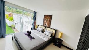 a bedroom with a bed with a stuffed animal on it at Crystal Bay Tropical Residence in Koh Samui