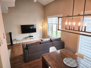 a living room with a couch and a tv at Les Condos de la Montagne 2 in Beaupré
