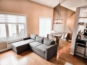 ein Wohnzimmer mit Sofa und Tisch in der Unterkunft Les Condos de la Montagne 2 in Beaupré