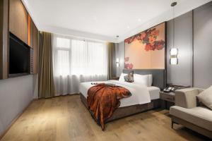 a hotel room with a bed and a television at Yiwu Manxin Hotel in Yiwu