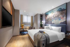 a hotel room with a large bed and a flat screen tv at Yiwu Manxin Hotel in Yiwu