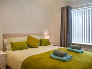 a bedroom with a large bed with two towels on it at Wylandre in Amlwch