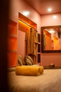 um quarto com uma cama com um espelho e um roupão em VA Villa Jimbaran Bali em Jimbaran
