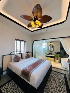 a bedroom with a bed with a ceiling fan at Phuong Nam Hotel An Giang in Long Xuyên