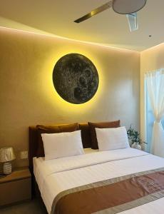 a bedroom with two beds with a moon on the wall at Phuong Nam Hotel An Giang in Long Xuyên