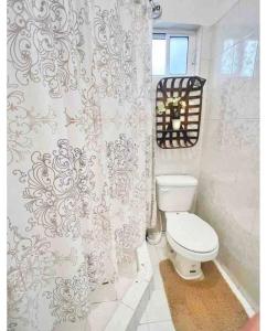 La salle de bains est pourvue de toilettes et d'un rideau de douche. dans l'établissement Departamento familiar Sweet Home, à Reynosa