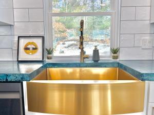 una cocina con fregadero de oro frente a una ventana en Luxury 4 bedroom 2 bath Lake Views, en Marlborough