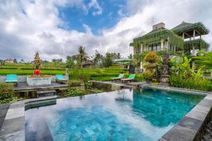 une villa avec une piscine et une maison dans l'établissement Cahaya Ubud Villa, à Ubud