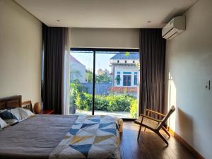 a bedroom with a bed and a large window at Noi Bai Flight Path Homestay in Hanoi