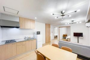 eine Küche und ein Wohnzimmer mit einem Tisch und einem Sofa in der Unterkunft SEED Tanimachi 6-chome in Osaka