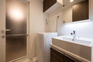 a bathroom with a sink and a shower at Wellsquareism Otsuka in Tokyo