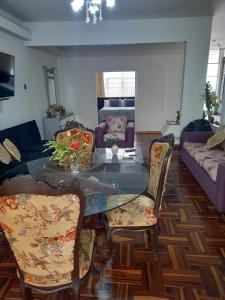 ein Wohnzimmer mit einem Glastisch und Stühlen in der Unterkunft Departamento en Pueblo Libre in Lima