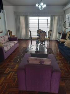 ein Wohnzimmer mit einem lila Sofa und einem Tisch in der Unterkunft Departamento en Pueblo Libre in Lima