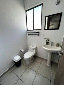 Baño blanco con aseo y lavamanos en Casa completa en condominio privado con alberca, en Miranda