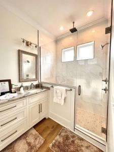 a white bathroom with a shower and a sink at Osprey -Luxury 3BDR Beach House in Orange Beach